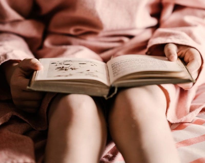 Little Girl Reading with Book on Her Lap